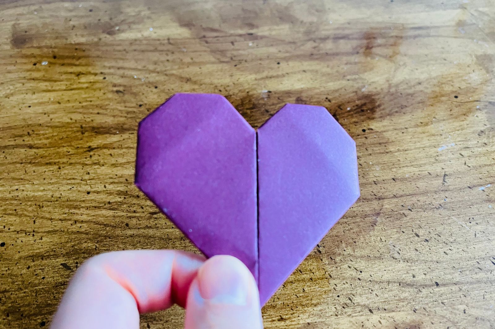 origami heart being held with fingers